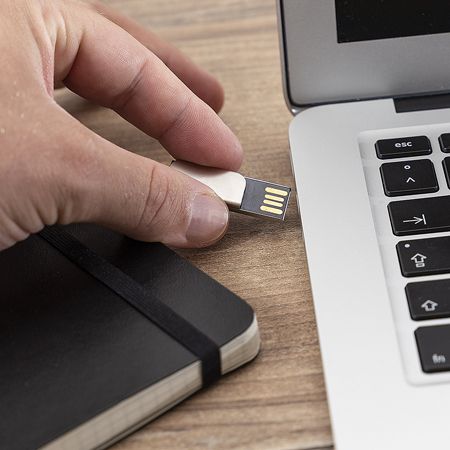 USB-Stick Firstnotice an einem Notizbuch befestigt